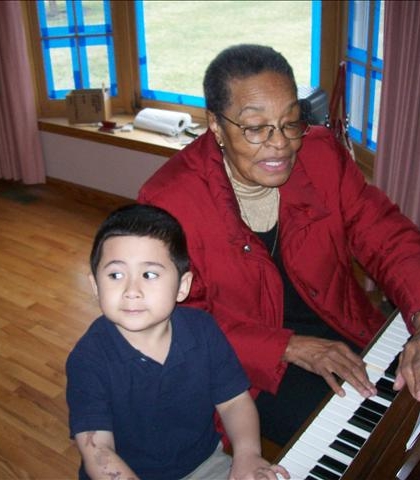 Piano lessons from great Aunt Emily! Is he paying attention? Looks like he is really interested!?