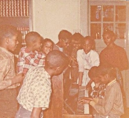 At Payne School, Miss Alma Irvine's 5th grade class: Lt. Billy Wooten, Robert Shaw, Reginald Williams, lt. Diane Saunders, lt. Diane Saunders, lt. Penny Early, Sarah Thomas, Kervinie Davis Alexander, looking on Jimmy Brown watching me play the piano!